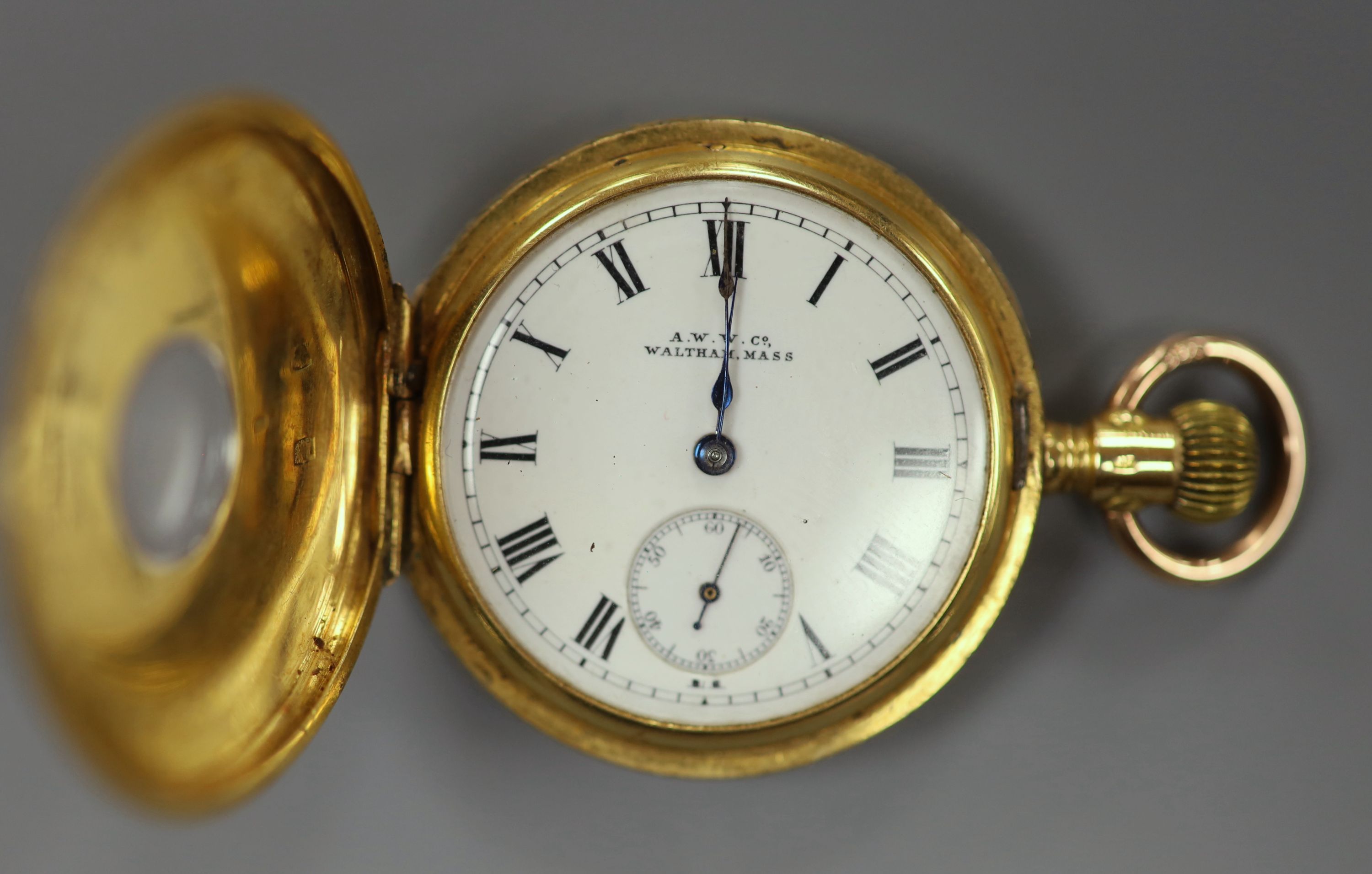 An American Waltham engraved 18ct yellow metal half hunter fob watch, case diameter 32mm, gross 44.5 grams.
